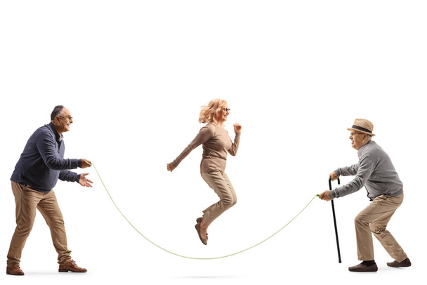 Elderly man playing a skipping rope with a woman isolated on white background - Foto, Imagem