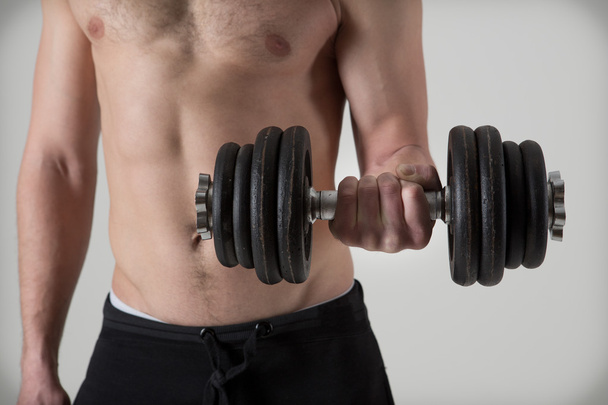 Muscular culturista haciendo ejercicios con pesas
 - Foto, imagen