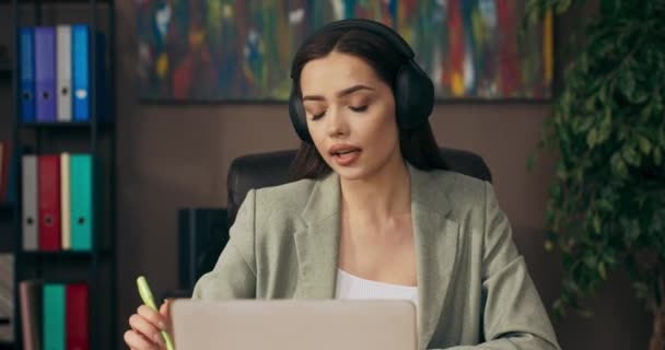 Confused young woman sitting at office table working taking cellphone looking at chats . - Filmagem, Vídeo