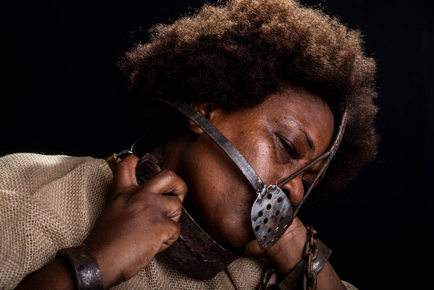Portret czarnej kobiety uwięzionej w żelaznej masce na twarzy przedstawiającej niewolnicę Anastacię. Niewolnictwo w Brazylii. - Zdjęcie, obraz