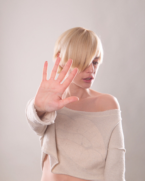 Блондинка с короткими волосами держит руку в знак протеста изолированы
 - Фото, изображение