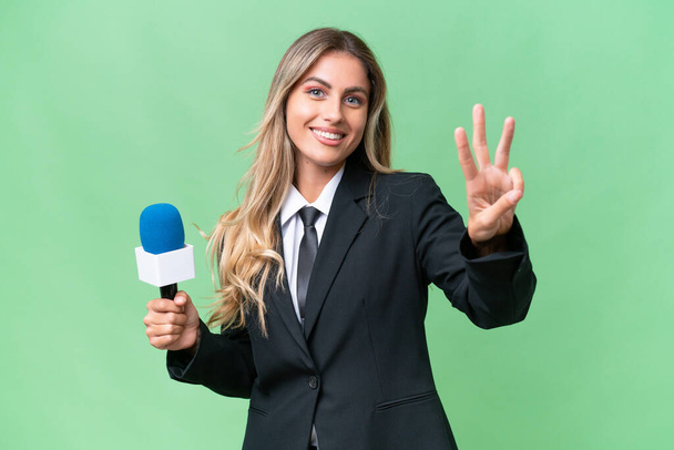 Young pretty Uruguayan tv presenter over isolated background happy and counting three with fingers - Photo, Image