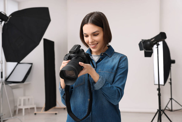 Professional photographer with camera in modern photo studio - Foto, afbeelding