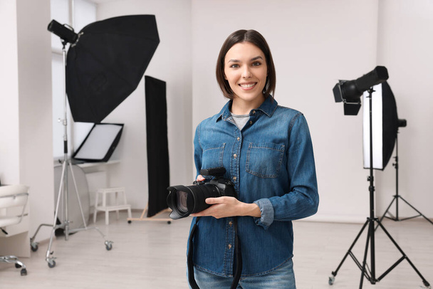 Professional photographer with camera in modern photo studio - Foto, afbeelding