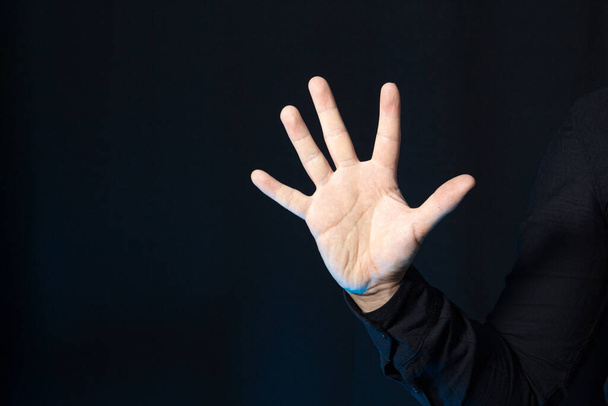 Persona de negocios con cinco dedos levantados aislados en negro. Detener gesto con espacio de copia. - Foto, Imagen