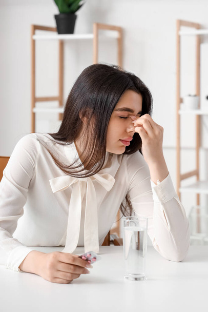 Sick woman with pills in office - Photo, Image