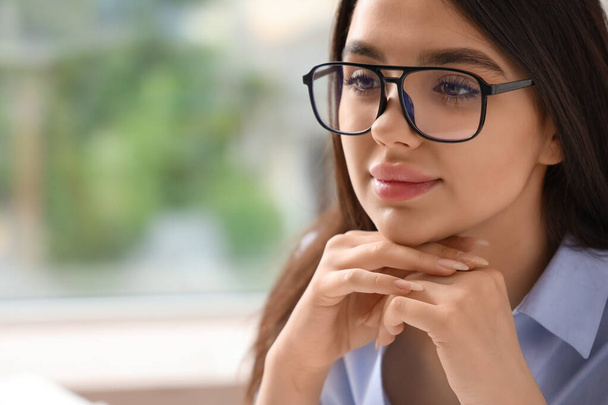 Kaunis nuori nainen yllään lasit toimistossa - Valokuva, kuva