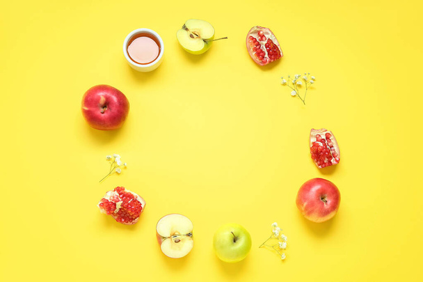 Frame made of fresh fruits, honey and gypsophila flowers on yellow background. Rosh hashanah (Jewish New Year) celebration - Photo, Image
