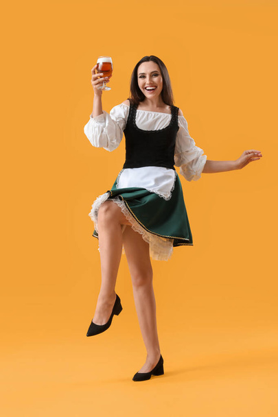 Gyönyörű Octoberfest pincérnő sör tánc sárga háttér - Fotó, kép