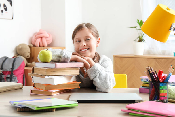 Kleines Mädchen mit einem Stapel Bücher beim Unterricht zu Hause - Foto, Bild