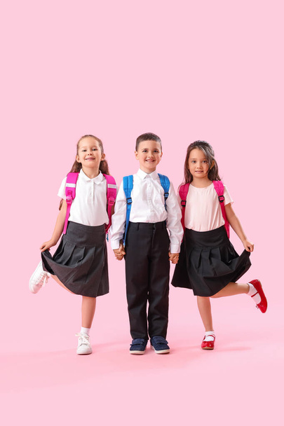 Kleine schoolkinderen op roze achtergrond - Foto, afbeelding
