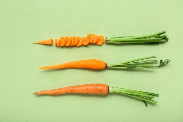 Sliced, peeled and fresh carrots on light green background - Fotoğraf, Görsel