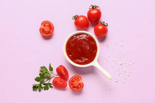 Miska z pastą pomidorową i świeżych warzyw na tle liliowym - Zdjęcie, obraz