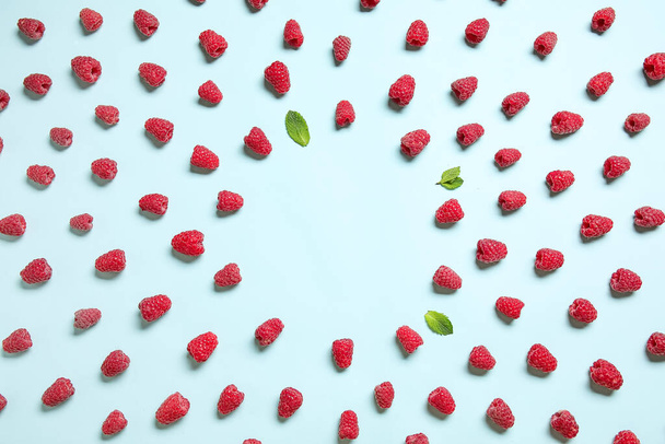 Frame made of fresh raspberries and mint on blue background - Foto, immagini