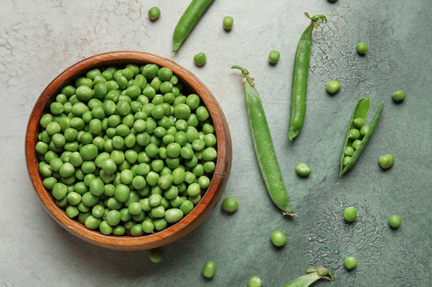Bowl with fresh green peas on grunge background - Foto, Bild