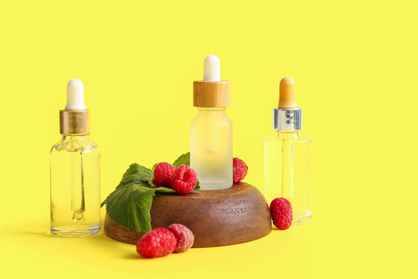 Pullot kosmeettisia vadelmaöljyä keltaisella pohjalla - Valokuva, kuva