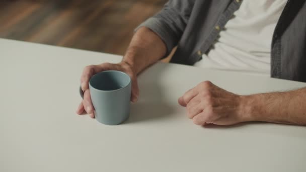 Lähikuva Male Hands with Cup of Tea. Vanhat Mansin kädet pitävät mukia, jossa on luonnollista kivennäisvettä. Tee vanhimmalle. Juomaveden edut. - Materiaali, video