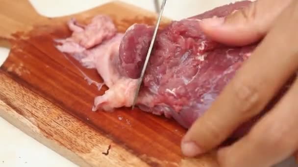 marhahúst szeletelni egy fából készült vágódeszkán egy éles késsel. ürü- és marhahús-témákhoz alkalmas. - Felvétel, videó