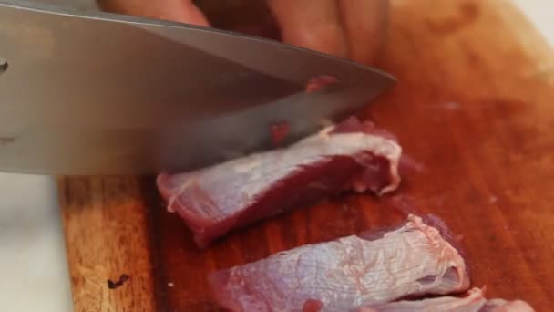 marhahúst szeletelni egy fából készült vágódeszkán egy éles késsel. ürü- és marhahús-témákhoz alkalmas. - Felvétel, videó