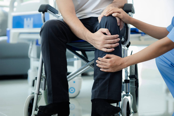 Patient masculin assis dans un fauteuil roulant subissant un examen médical avec un médecin spécialiste, le traitement des blessures Obtenir un traitement médical du médecin spécialiste peut obtenir le bon et bon traitement - Photo, image