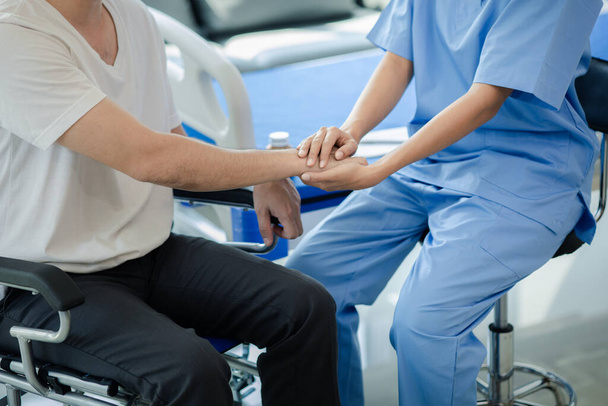 Männlicher Patient sitzt im Rollstuhl und unterzieht sich einer ärztlichen Untersuchung beim Facharzt, um Verletzungen zu behandeln. - Foto, Bild