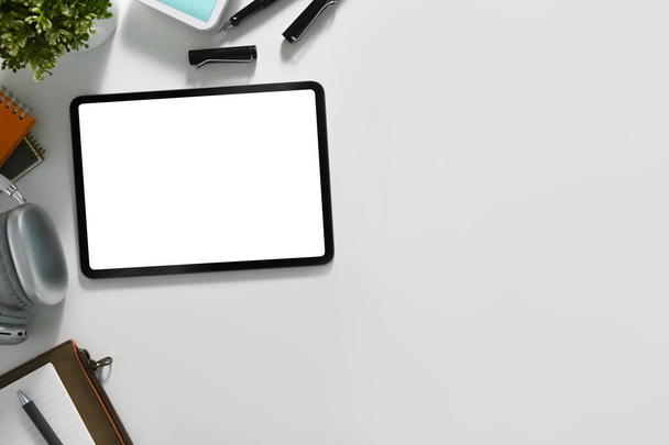 Escritorio blanco con tableta digital, teclado y bloc de notas. Colocación plana, vista superior con espacio para copiar. - Foto, imagen