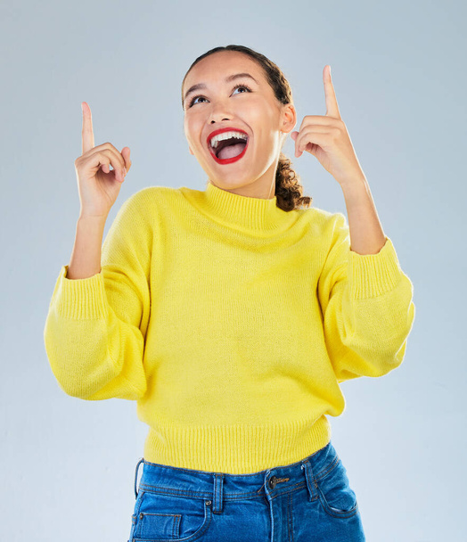 Wow, excited and woman pointing to presentation, news or announcement for creative opportunity. Show, information and happy person or model in surprise, idea or solution on a studio white background. - Фото, зображення