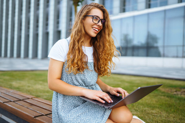 Young woman with wireless headphones calling on laptop, talk by webcam, video conference. Concept of education, online, business, blog or freelance. - 写真・画像