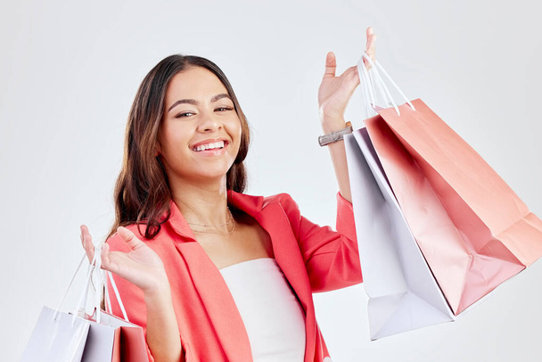 Fashion, studio or happy woman with shopping bags for retail sale, product offer or discount deal. Choice, customer or girl shopper holding gift, package or products on promotion on white background. - Foto, imagen