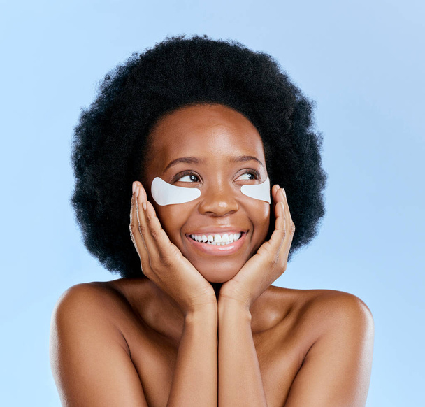 Beauty, skincare and eye mask with black woman in studio for facial, cosmetics and dermatology. Spa, wellness and self care with face of female person on blue background for salon, glow and detox. - Fotoğraf, Görsel