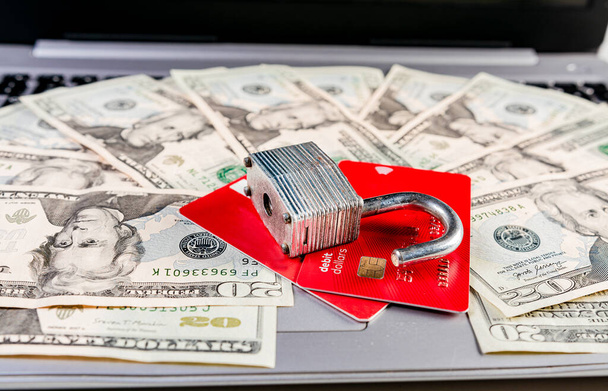 Close up of Padlock on top of credit card on dollar bills, Concept of credit card information theft. Padlock with credit card on top of dollars - Photo, Image