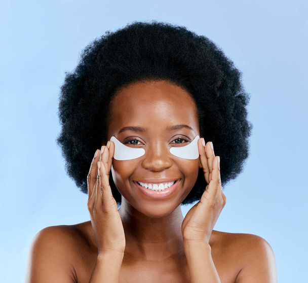 Beauty, skincare and eye mask with portrait of black woman in studio for facial, cosmetics or dermatology. Spa, wellness and self care with face of person on blue background for salon, glow and detox. - Fotoğraf, Görsel