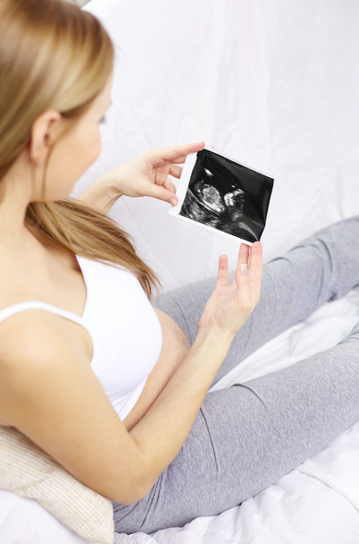 happy pregnant woman with ultrasound image at home - Zdjęcie, obraz