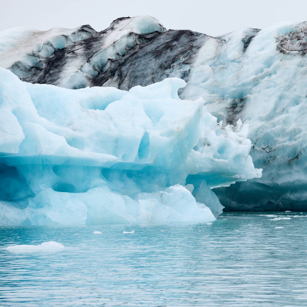 Айсберг в Исландии. Айсберг, впадающий в Иокульсарлонскую лагуну, отделенный от фронта ледника. - Фото, изображение