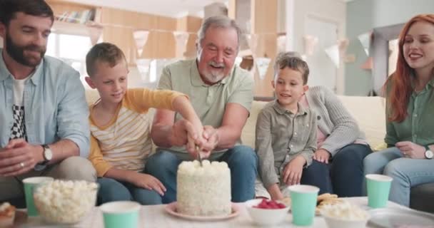 Geburtstag, große Familie und gemeinsames Kuchenschneiden zum Festessen, Feiern oder Dessert. Happy, help and kid mit einem Messer für eine süße Leckerei mit Eltern, Großeltern und Geschwistern in einem Haus für eine Leckerei. - Filmmaterial, Video