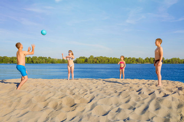 Happy family plays beach volleyball on the sand. The concept of a healthy lifestyle. Family vacation, summer vacation - Fotoğraf, Görsel
