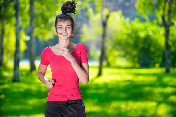 屋外緑豊かな公園で走っている女性 - 写真・画像