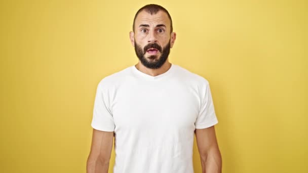Young hispanic man sneezing over isolated yellow background - Footage, Video