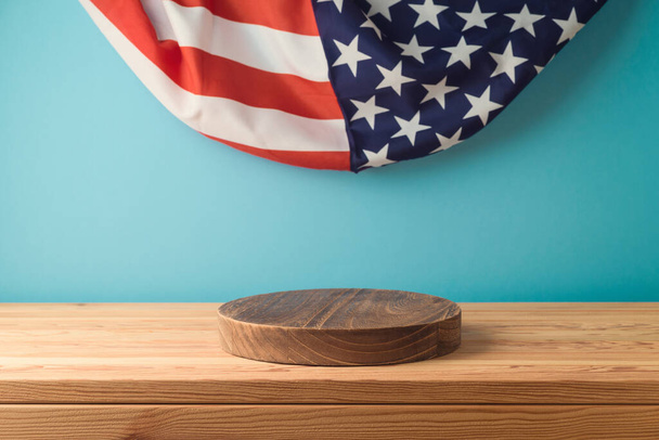 Empty wooden podium log on table over USA flag background. American national holiday mock up for design and product display - Foto, afbeelding