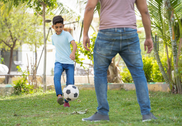 Baba ve oğlunun parkta futbol oynarken yakın çekimi - yaz tatili kavramı, ilişki ve aktif yaşam tarzı - Fotoğraf, Görsel