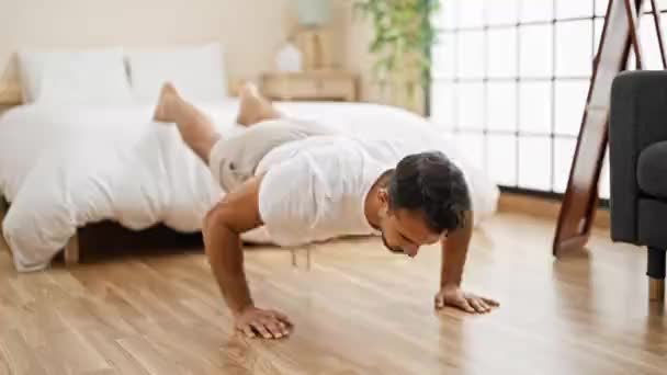 Mladý hispánec muž trénink push up v ložnici - Záběry, video