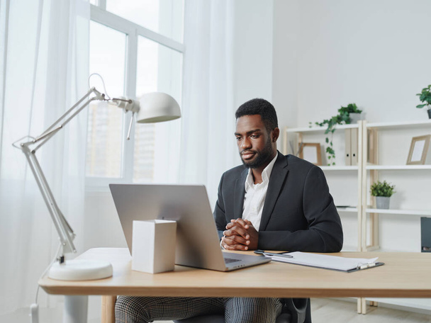 чоловік комп'ютер онлайн чат студентська робота підприємець технології ноутбук людина дивиться офіс африканський виклик бізнес-освіта корпоративна робота афроамериканський посміхнений фрілансер - Фото, зображення