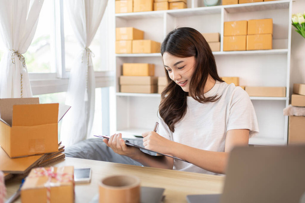 Woman Writing Customer Details for Shipping in Home Office, Packing Box and Writing Customer Information for Efficient Shipping, E-Commerce and Online Selling Concept. - Φωτογραφία, εικόνα