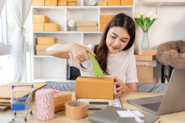 Efficient Home-Based Delivery, Woman Packing Items into Post Box for Customer Shipping, Online Shopping and Small Business Entrepreneurship, Packing box, Πώληση online, Ελεύθερη εργασία. - Φωτογραφία, εικόνα