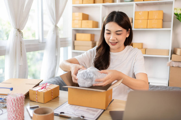 Efficient Home-Based Delivery, Woman Packing Items into Post Box for Customer Shipping, Online Shopping and Small Business Entrepreneurship, Packing box, Sell online, Freelance working. - Foto, afbeelding