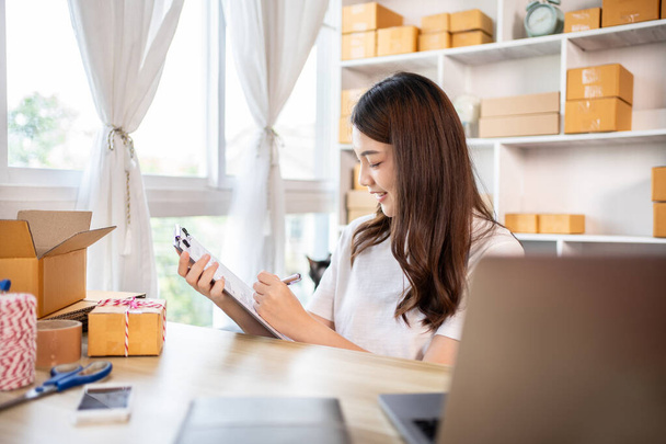 Online-Geschäft, Kleinunternehmer prüfen Bestände, um sie für die ordnungsgemäße Lieferung an Kunden vorzubereiten, Arbeiten von zu Hause aus: Verwaltung von E-Commerce-Operationen.  - Foto, Bild