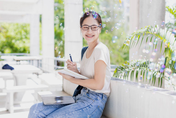 University teen girl happy smiling enjoy learning education. young woman writing note diary good memory. - 写真・画像