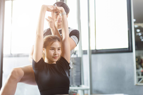 Personnes en bonne santé asiatique jeune femme sport exercice dans fitness gymnase sport club avec entraîneur personnel instructeurs aider à soutenir. - Photo, image