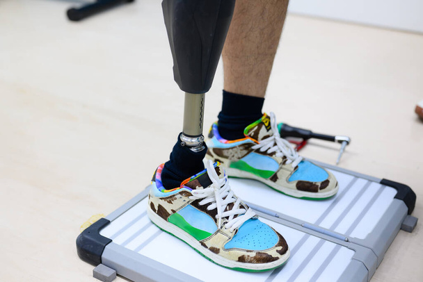 Pacjent niepełnosprawny sportowiec z niepełnosprawnością fizyczną wykonujący rutynowe ćwiczenia w pomieszczeniach, Osoby z zaawansowaną technologią w ośrodku zdrowia protetycznego, Nowa sztuczna produkcja kończyn dla osób niepełnosprawnych - Zdjęcie, obraz