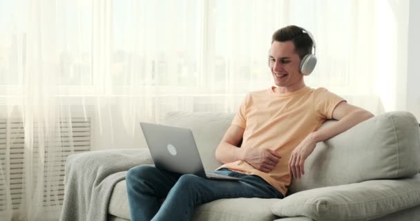 Um homem caucasiano produtivo conduz uma chamada de vídeo a partir do conforto de seu escritório em casa. Com seu confiável laptop como seu gateway virtual, ele se envolve em uma conversa profissional. - Filmagem, Vídeo